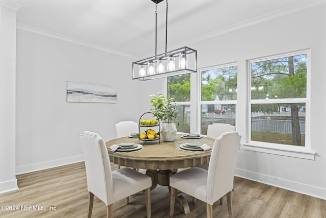 dining area with wood-type flooring and ornamental molding