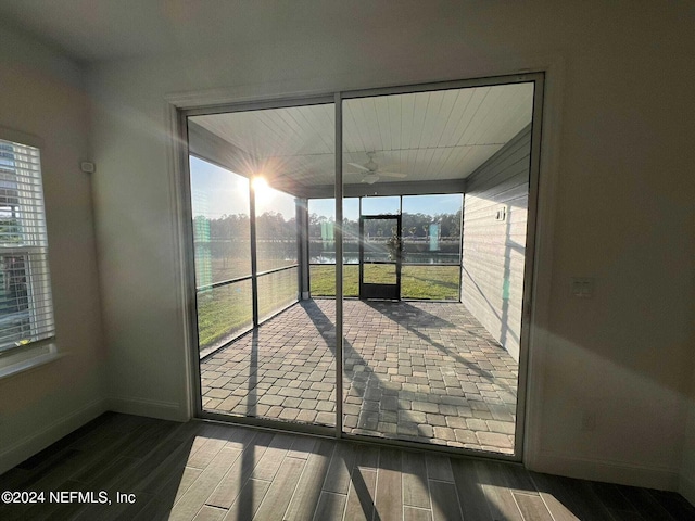 unfurnished sunroom featuring ceiling fan and plenty of natural light