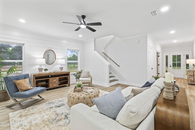 living room featuring ceiling fan, plenty of natural light, ornamental molding, and light hardwood / wood-style flooring