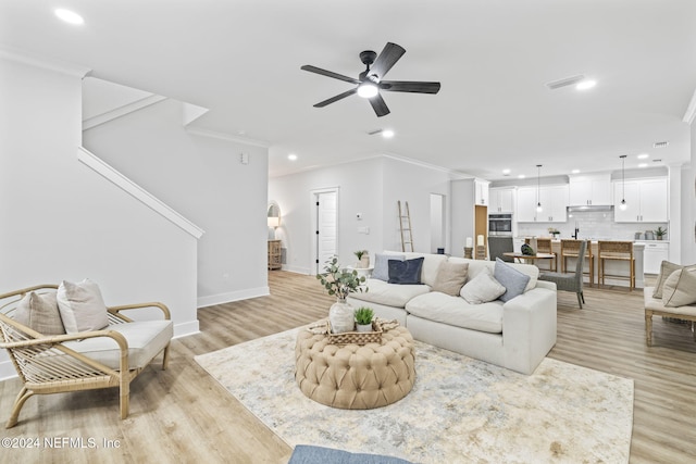 living room with ceiling fan, light hardwood / wood-style floors, and ornamental molding