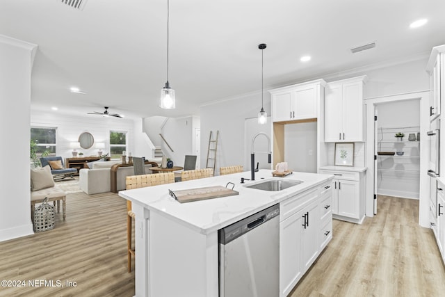 kitchen featuring sink, light hardwood / wood-style flooring, stainless steel dishwasher, decorative light fixtures, and white cabinetry