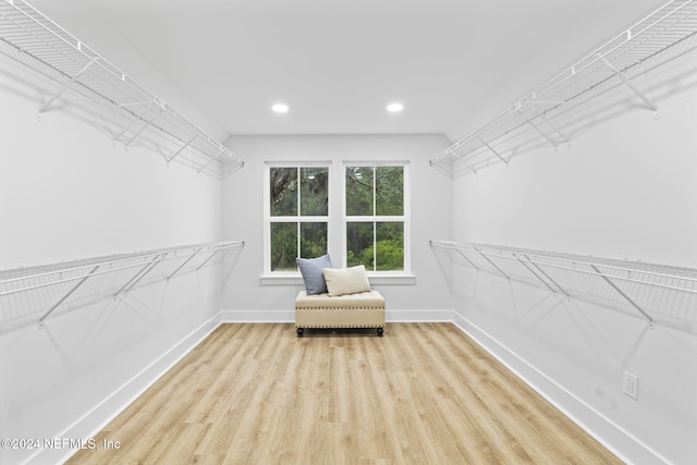 walk in closet with light hardwood / wood-style floors