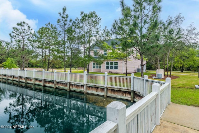 dock area with a lawn and a water view