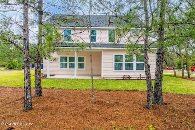 back of property featuring a lawn and a patio