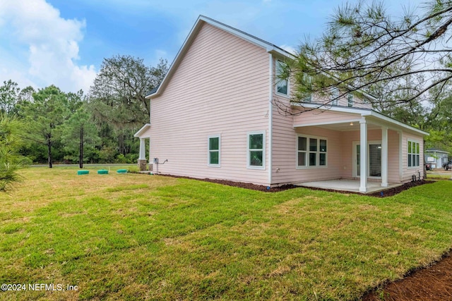 back of property with a lawn and a patio area