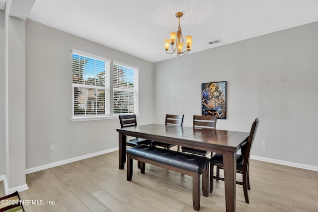 dining space featuring a notable chandelier and light hardwood / wood-style floors