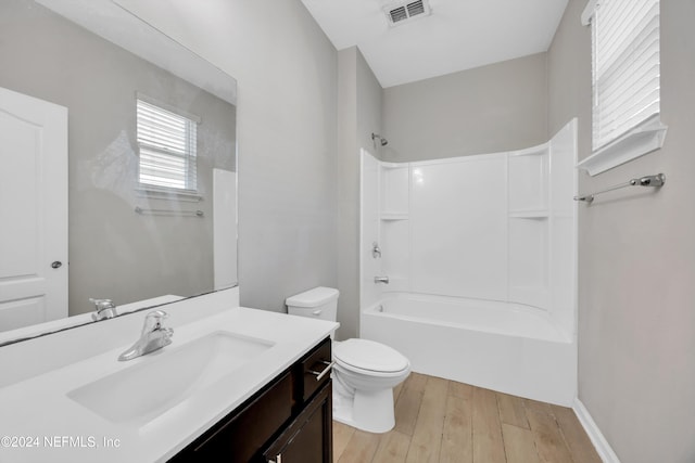 full bathroom with hardwood / wood-style floors, vanity, toilet, and washtub / shower combination