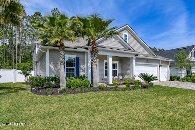 view of front of home featuring a front yard, a garage, and covered porch