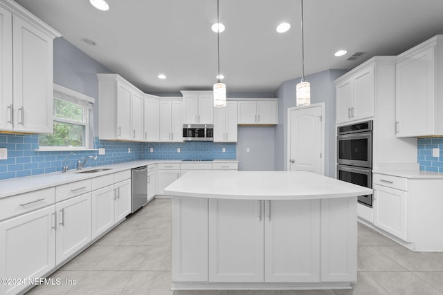 kitchen with a kitchen island, white cabinets, pendant lighting, and appliances with stainless steel finishes