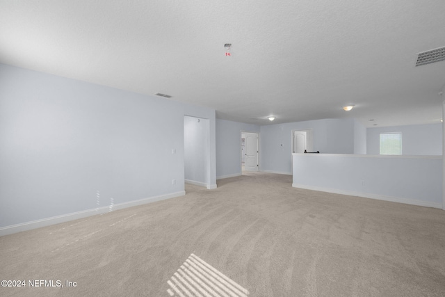 carpeted empty room featuring a textured ceiling