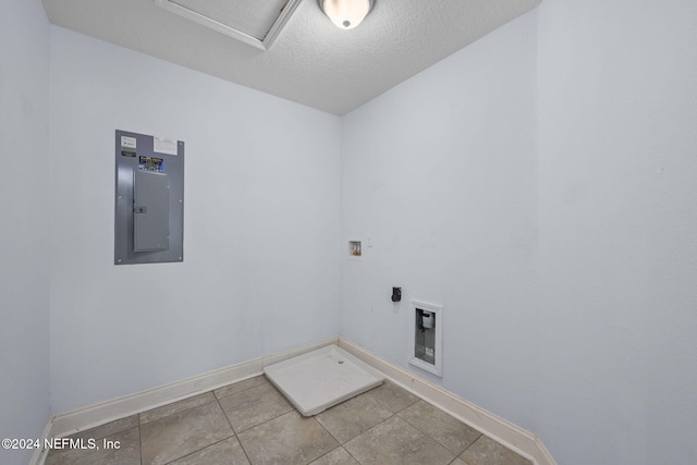 clothes washing area with washer hookup, hookup for an electric dryer, tile patterned floors, electric panel, and a textured ceiling