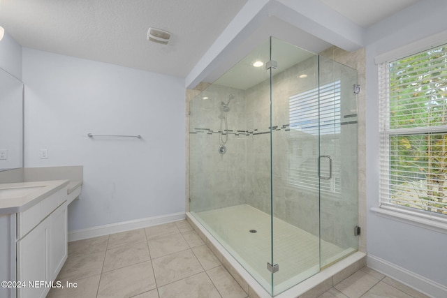 bathroom with tile patterned floors, vanity, and an enclosed shower