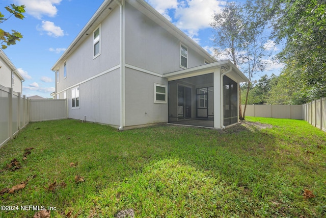 back of house with a sunroom and a yard