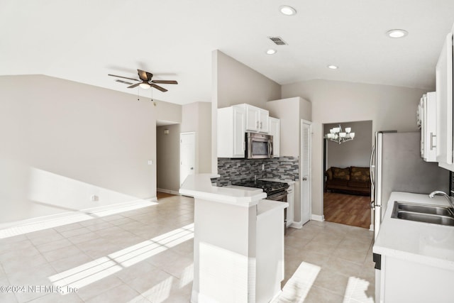 kitchen with white cabinetry, sink, lofted ceiling, light tile patterned flooring, and ceiling fan with notable chandelier