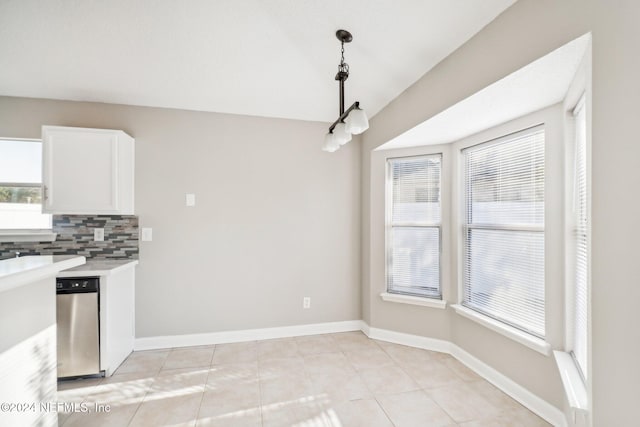 kitchen with white cabinets, backsplash, hanging light fixtures, and light tile patterned flooring