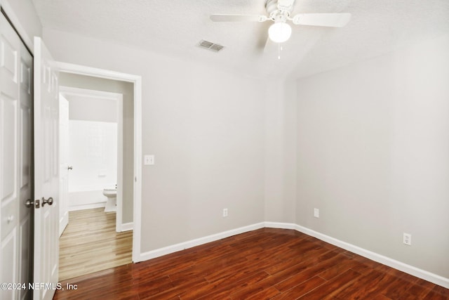 unfurnished room featuring a textured ceiling, ceiling fan, and dark wood-type flooring