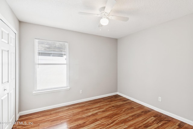 unfurnished room with ceiling fan, a textured ceiling, and light hardwood / wood-style flooring