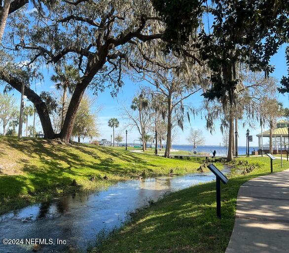 view of property's community featuring a lawn and a water view