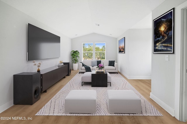 living room featuring light hardwood / wood-style flooring and vaulted ceiling