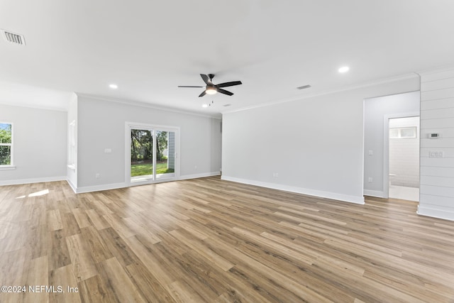 unfurnished living room with ceiling fan, ornamental molding, and light wood-type flooring