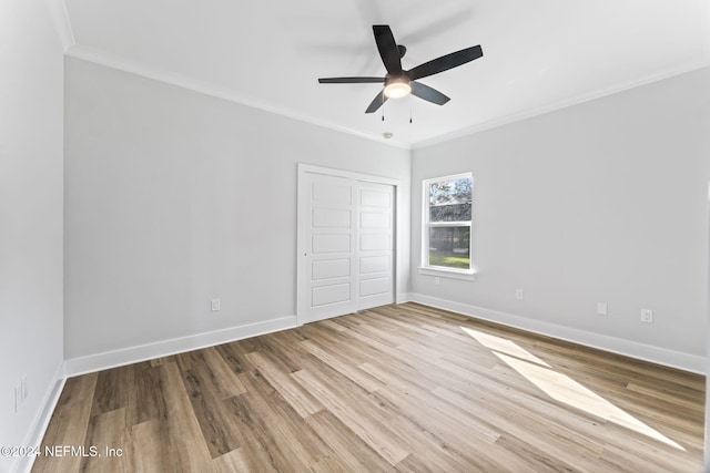 unfurnished bedroom featuring ceiling fan, light hardwood / wood-style floors, crown molding, and a closet