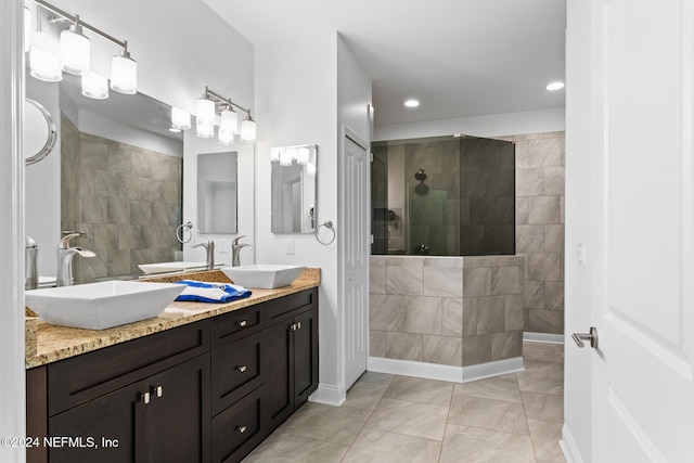 bathroom featuring tiled shower, vanity, and tile patterned flooring