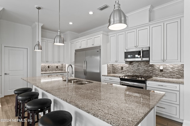 kitchen featuring dark hardwood / wood-style floors, an island with sink, and appliances with stainless steel finishes