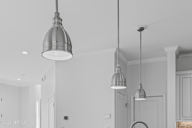 interior details featuring crown molding and hanging light fixtures