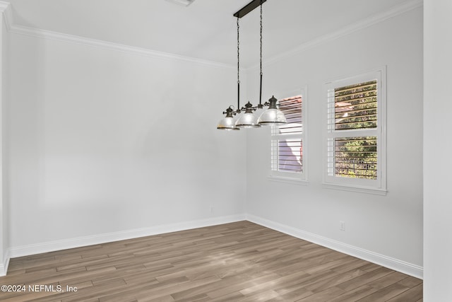 unfurnished dining area featuring hardwood / wood-style flooring, a notable chandelier, and ornamental molding