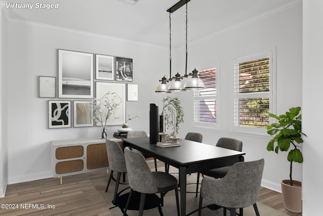 dining room featuring wood-type flooring, an inviting chandelier, and crown molding