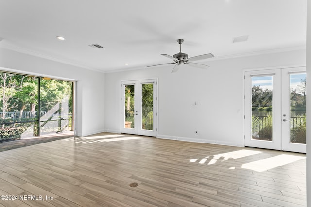 unfurnished room featuring french doors, light hardwood / wood-style floors, ceiling fan, and crown molding