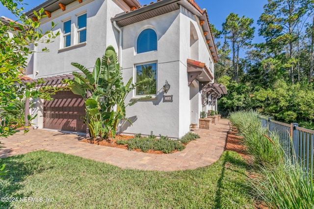 view of property exterior with a garage and a lawn