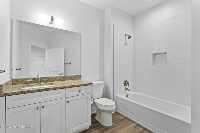 full bathroom featuring vanity, toilet, tiled shower / bath, and hardwood / wood-style flooring