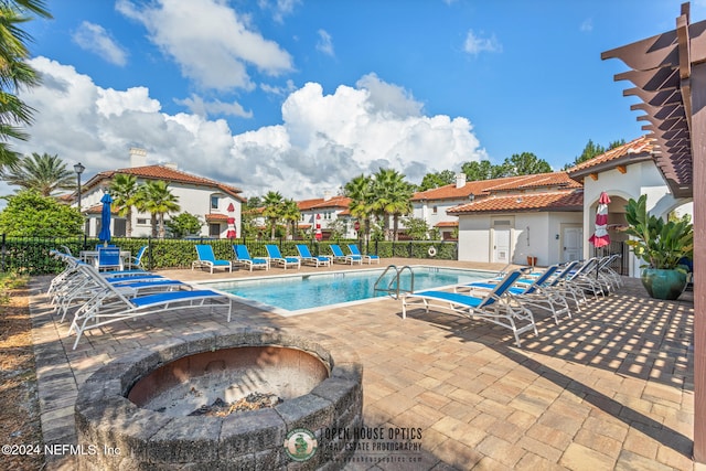 view of pool featuring a fire pit and a patio