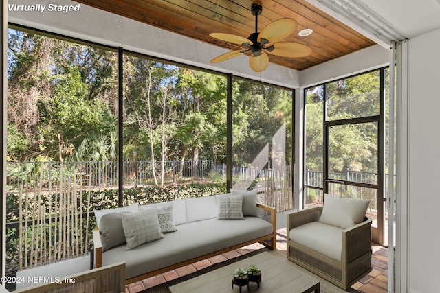 unfurnished sunroom with a wealth of natural light, ceiling fan, and wooden ceiling