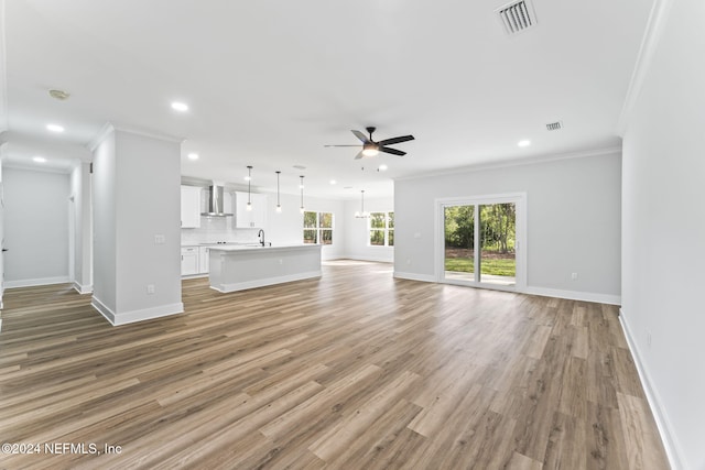 unfurnished living room with crown molding, ceiling fan, and wood-type flooring