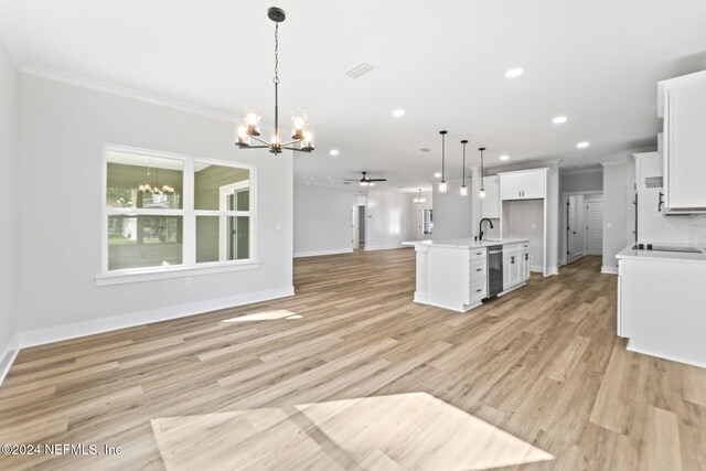 kitchen with white cabinetry, a kitchen island with sink, sink, and decorative light fixtures