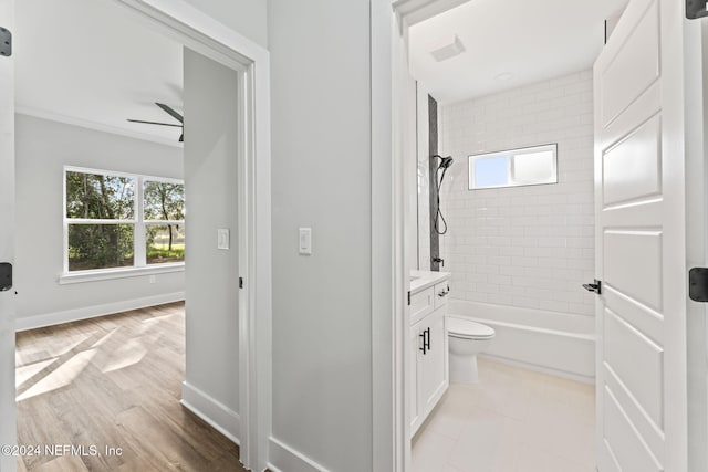 full bathroom with hardwood / wood-style flooring, ceiling fan, vanity, toilet, and tiled shower / bath