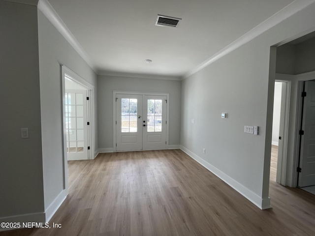 entrance foyer featuring crown molding, light wood-type flooring, and french doors