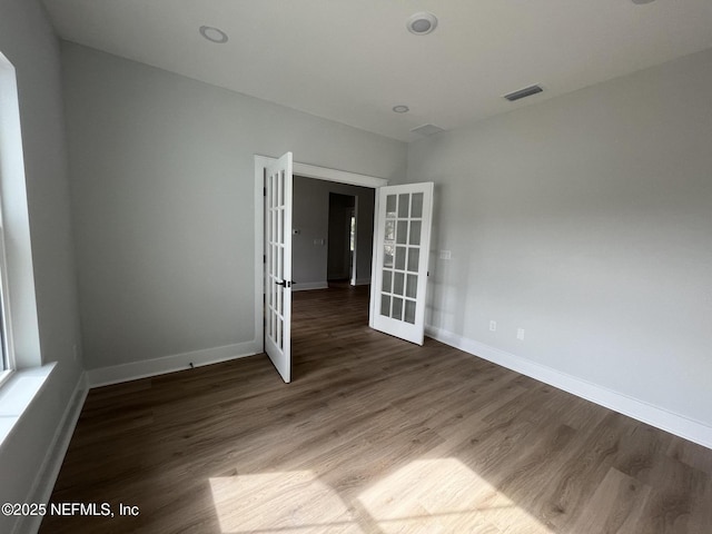 empty room featuring dark hardwood / wood-style floors and french doors