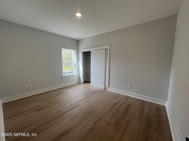 unfurnished bedroom with hardwood / wood-style floors and a closet