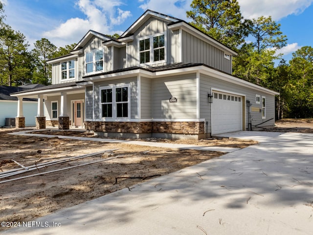 view of front of house featuring a porch, a garage, and central AC