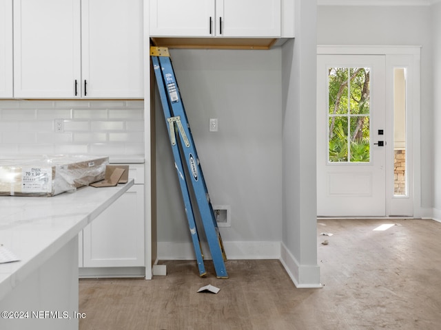 kitchen with decorative backsplash, light stone countertops, and white cabinets