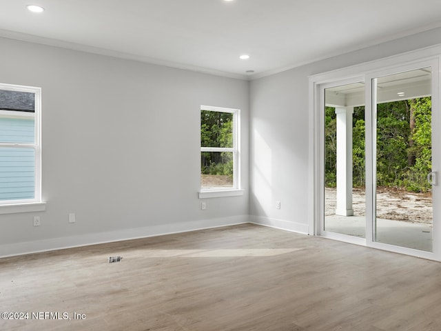 unfurnished room featuring light wood-type flooring and crown molding