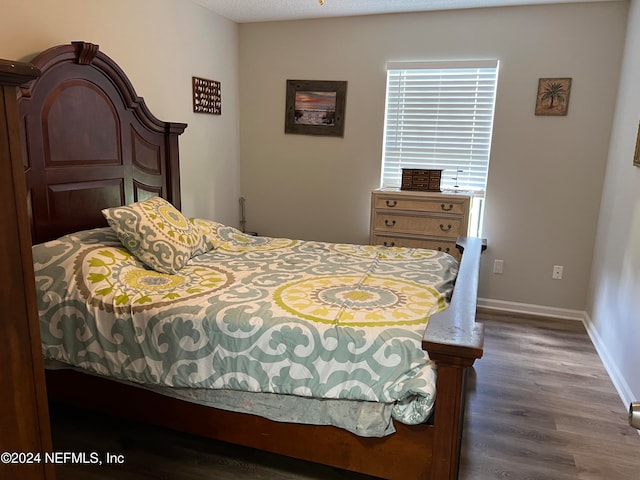 bedroom with dark hardwood / wood-style flooring and a textured ceiling