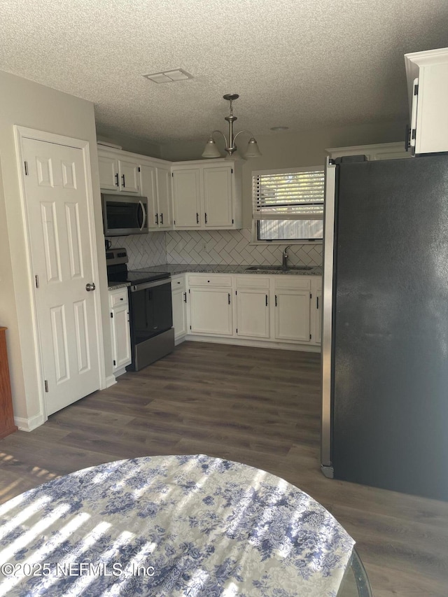 kitchen featuring stainless steel appliances, white cabinetry, tasteful backsplash, and sink