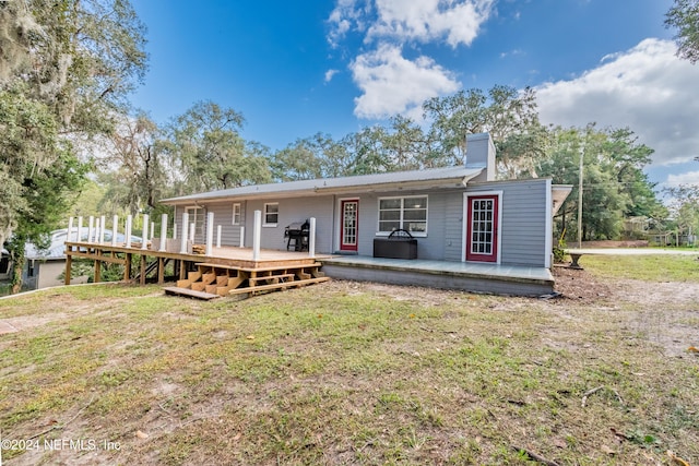 view of front facade with a deck and a front lawn