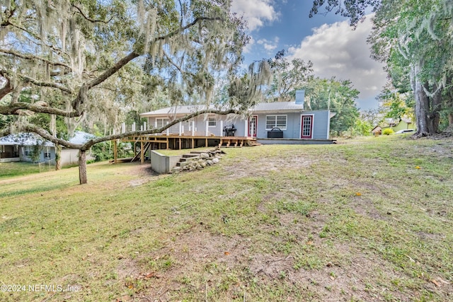 back of property featuring a lawn and a wooden deck