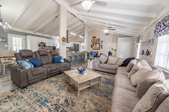 living room with hardwood / wood-style floors, beamed ceiling, and ceiling fan with notable chandelier