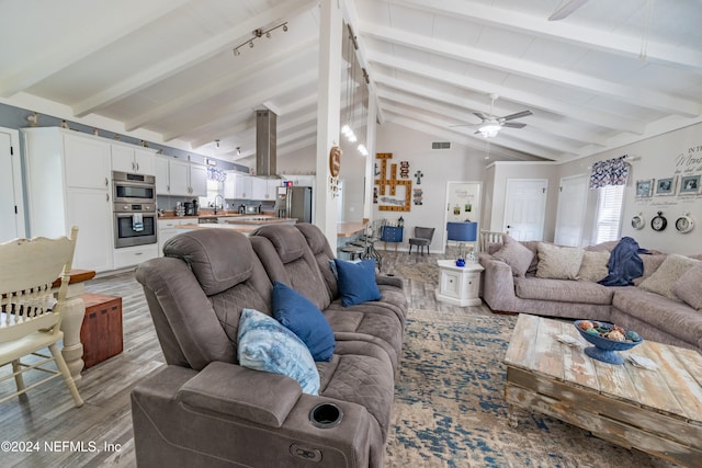 living room with high vaulted ceiling, sink, ceiling fan, beamed ceiling, and light hardwood / wood-style floors